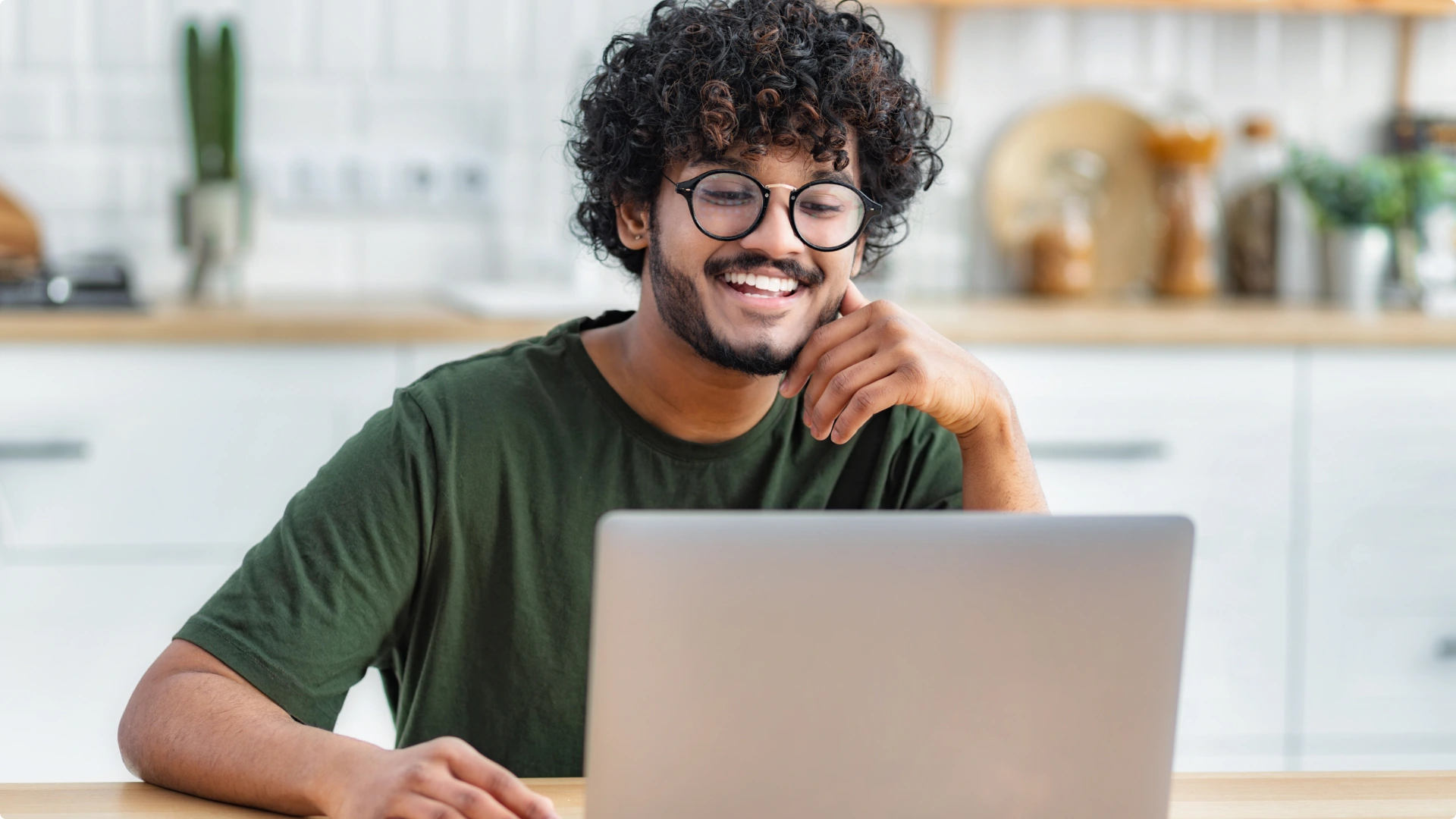 Jovem estudante sorridente usando notebook em casa para ensino a distância