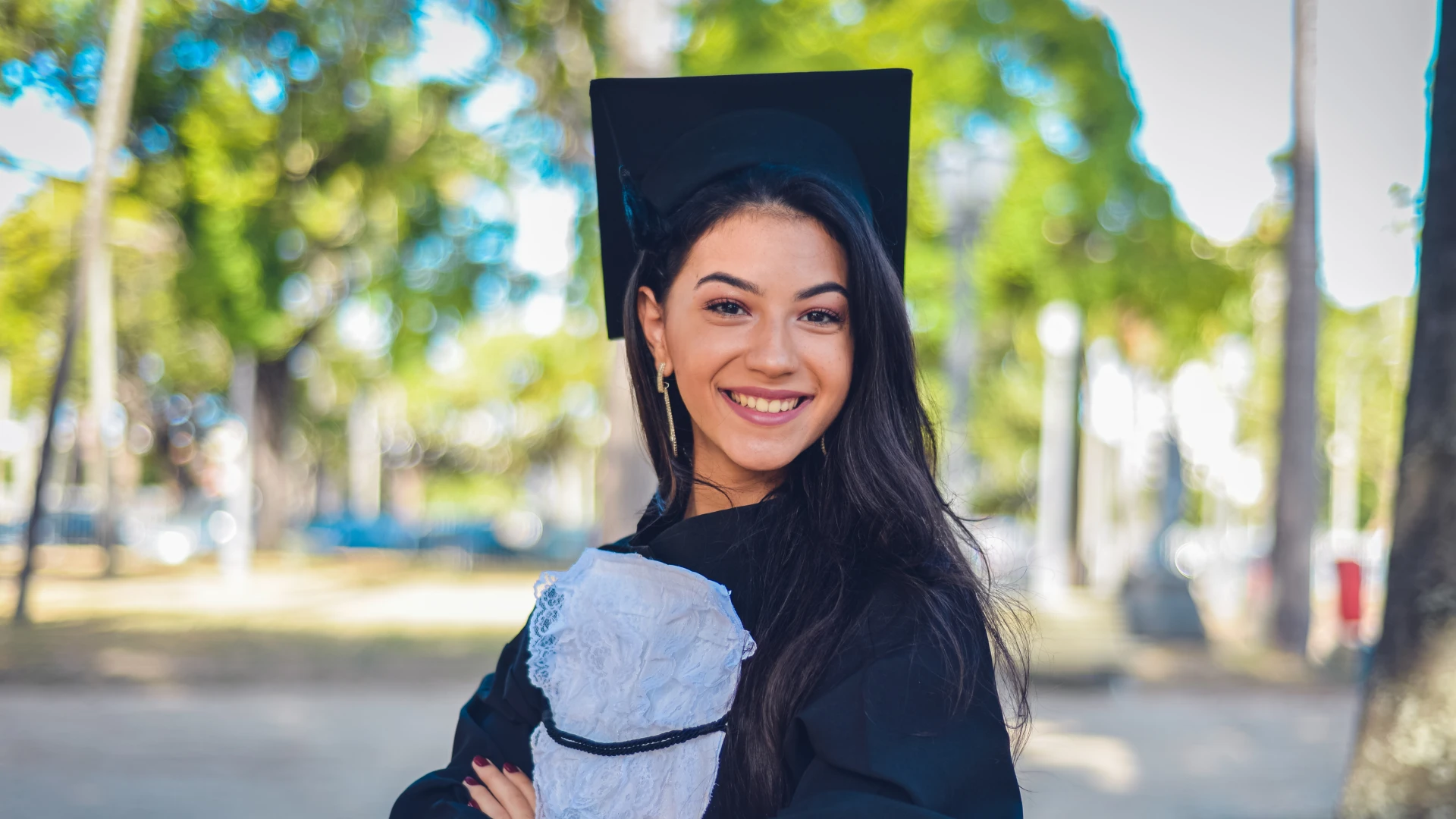 Estudante universitária celebrando a conquista da formatura em uma cerimônia de colação de grau ao ar livre