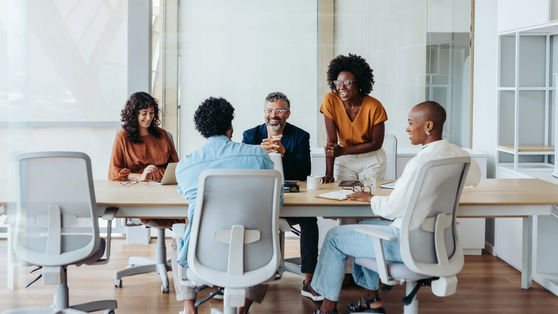 Equipe diversa e profissional colaborando em reunião de negócios em um escritório moderno