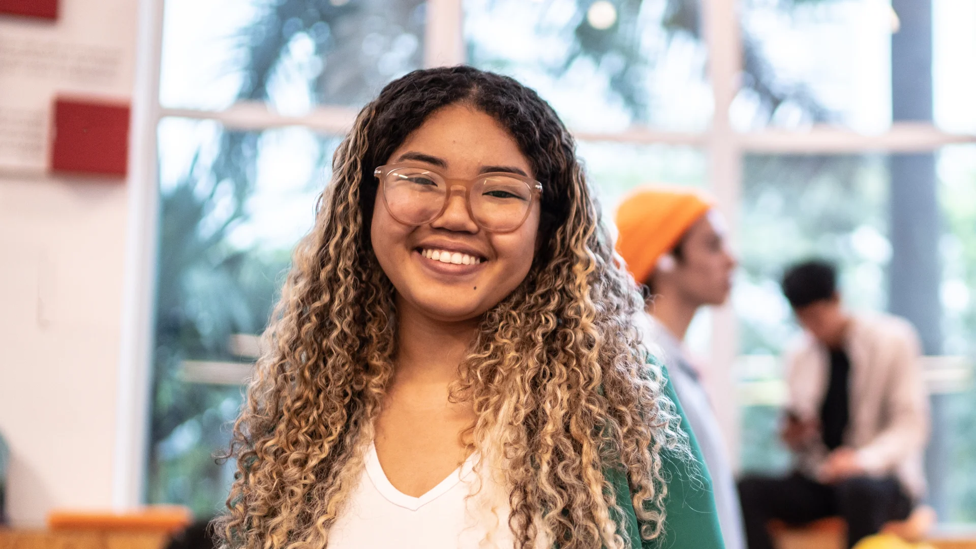 Estudante jovem e feliz em ambiente acadêmico representando a vida universitária e diversidade estudantil