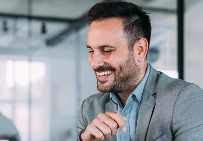 Profissional de negócios sorrindo no ambiente de trabalho corporativo para representar sucesso e satisfação profissional