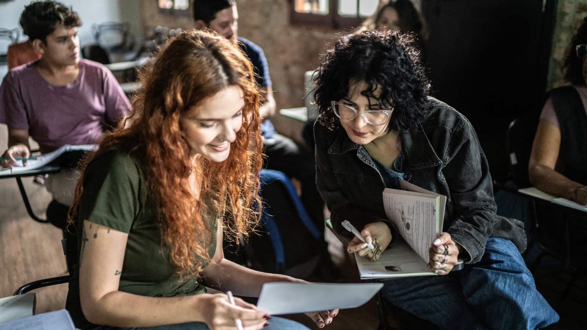 Estudantes universitárias colaborando em um projeto em sala de aula