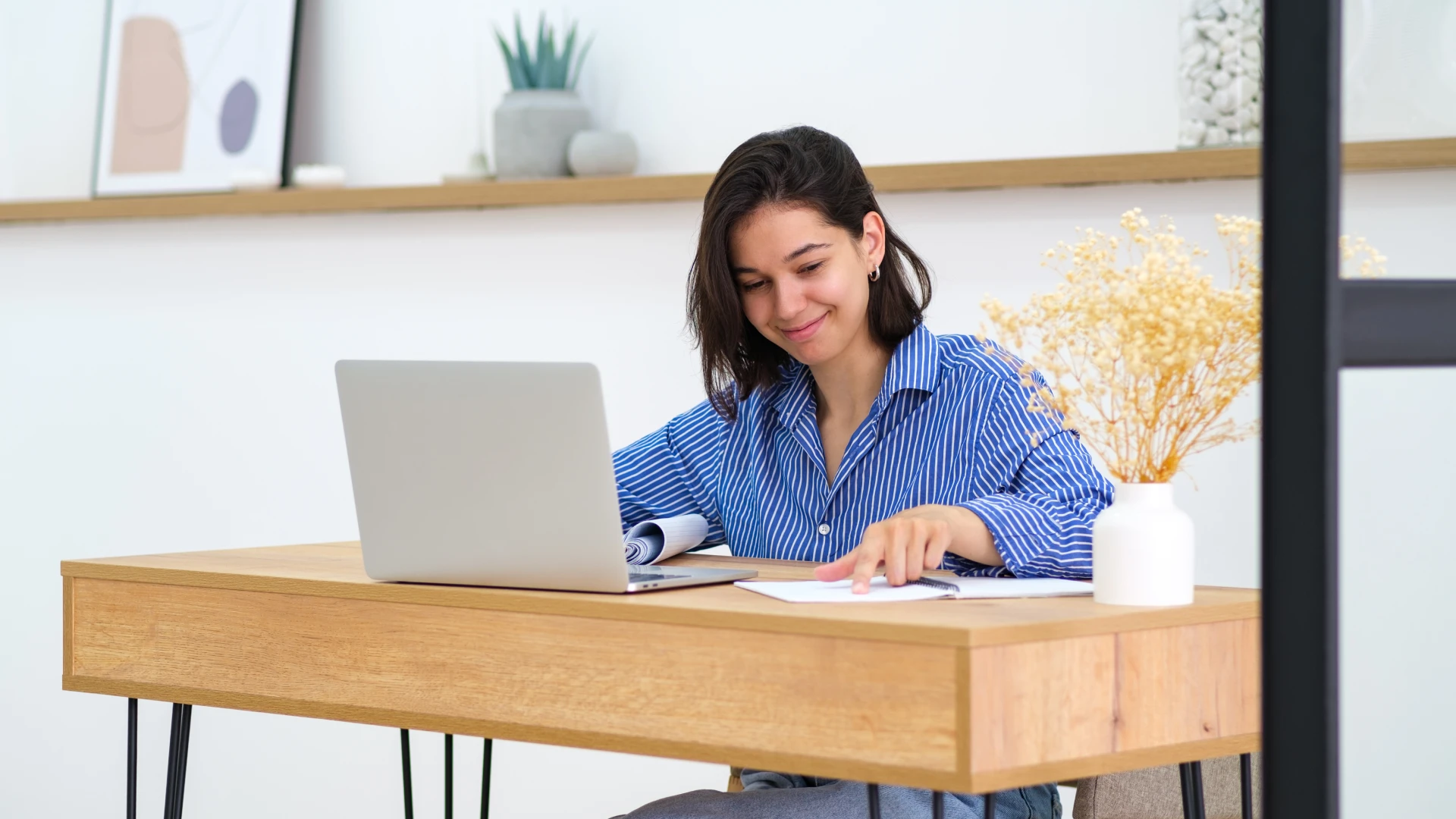 Estudante jovem trabalhando em um notebook em uma mesa de escritório moderna