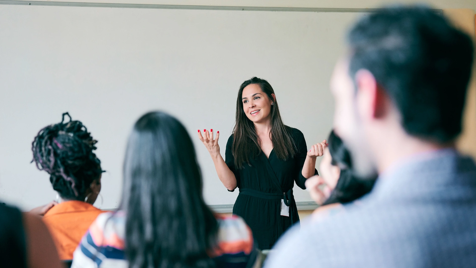 Professora ministrando aula para alunos em sala de aula universitária
