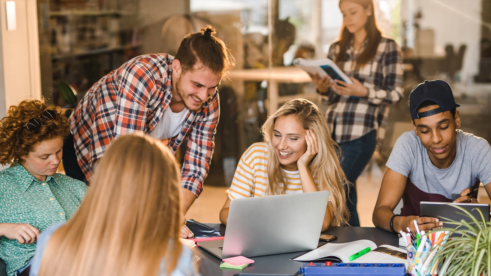 Grupo de estudantes universitários estudando juntos em um ambiente colaborativo com notebook
