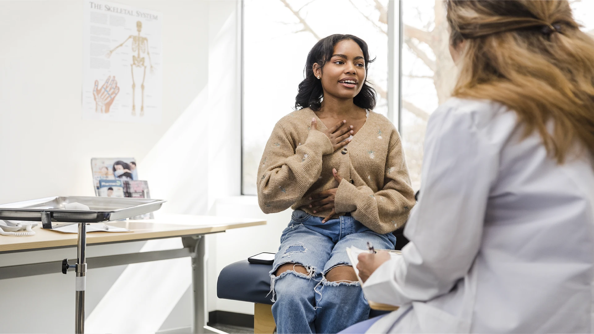 Paciente jovem conversando com médico em consultório clínico