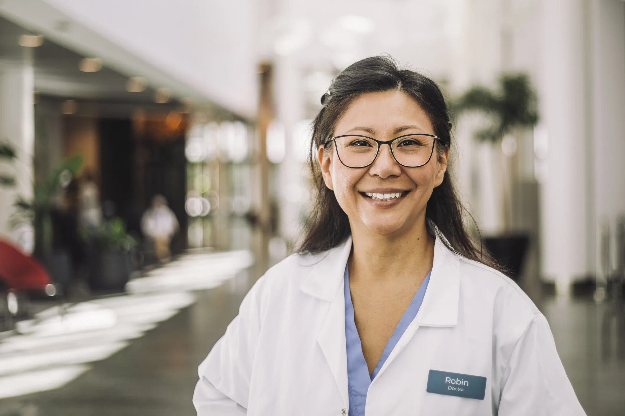 Retrato de uma médica profissional sorrindo no ambiente hospitalar para atendimento de pacientes