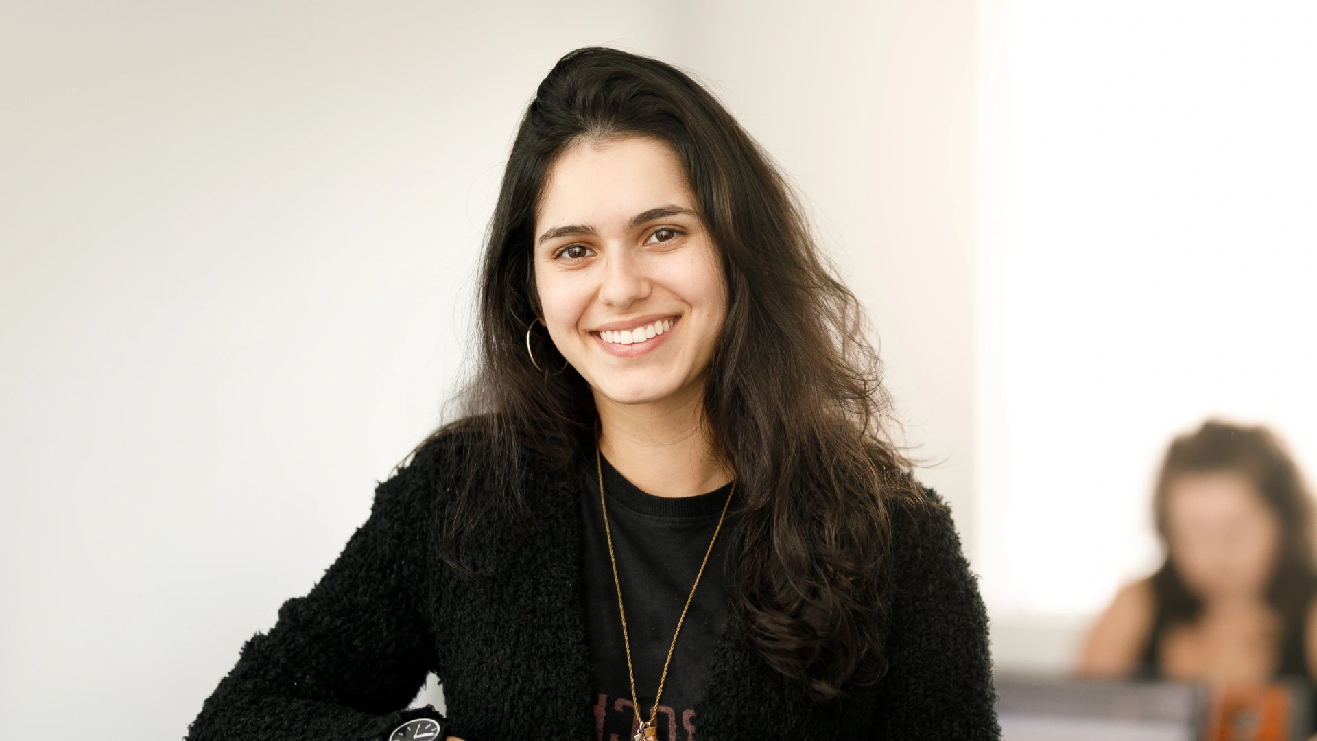 Retrato de uma jovem universitária sorridente em um ambiente de estudo ou escritório