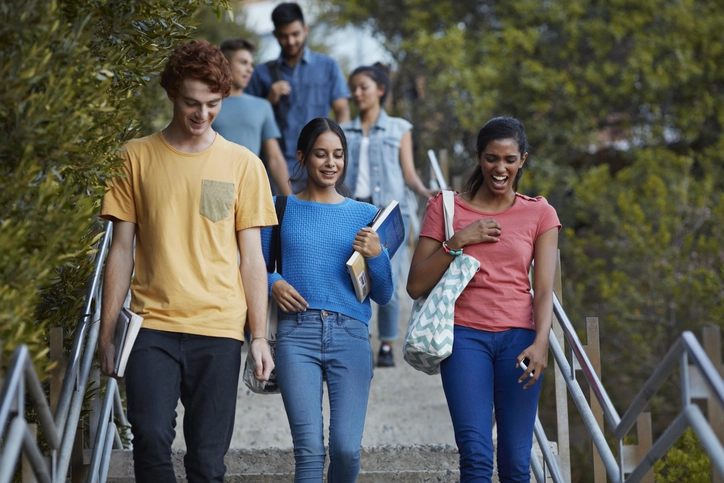 Grupo de estudantes universitários caminhando pelas escadas de um campus