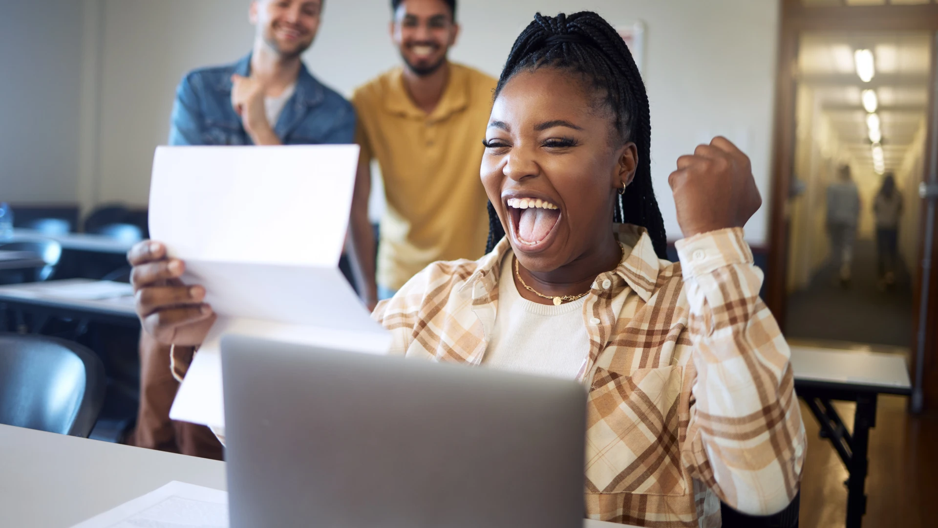 Estudante universitária celebrando a conquista de sua aprovação acadêmica com amigos na sala de aula