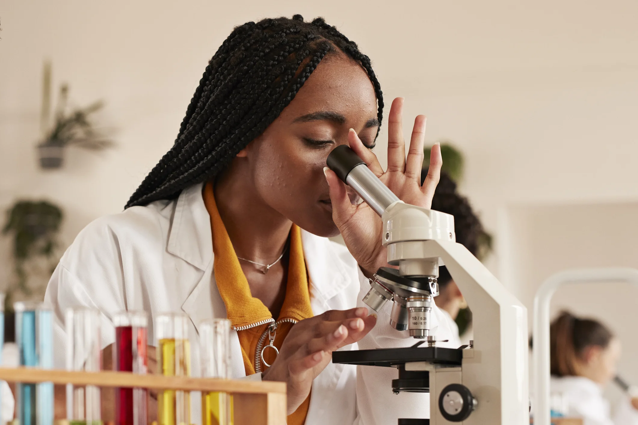 Estudante de ciências usando microscópio em laboratório