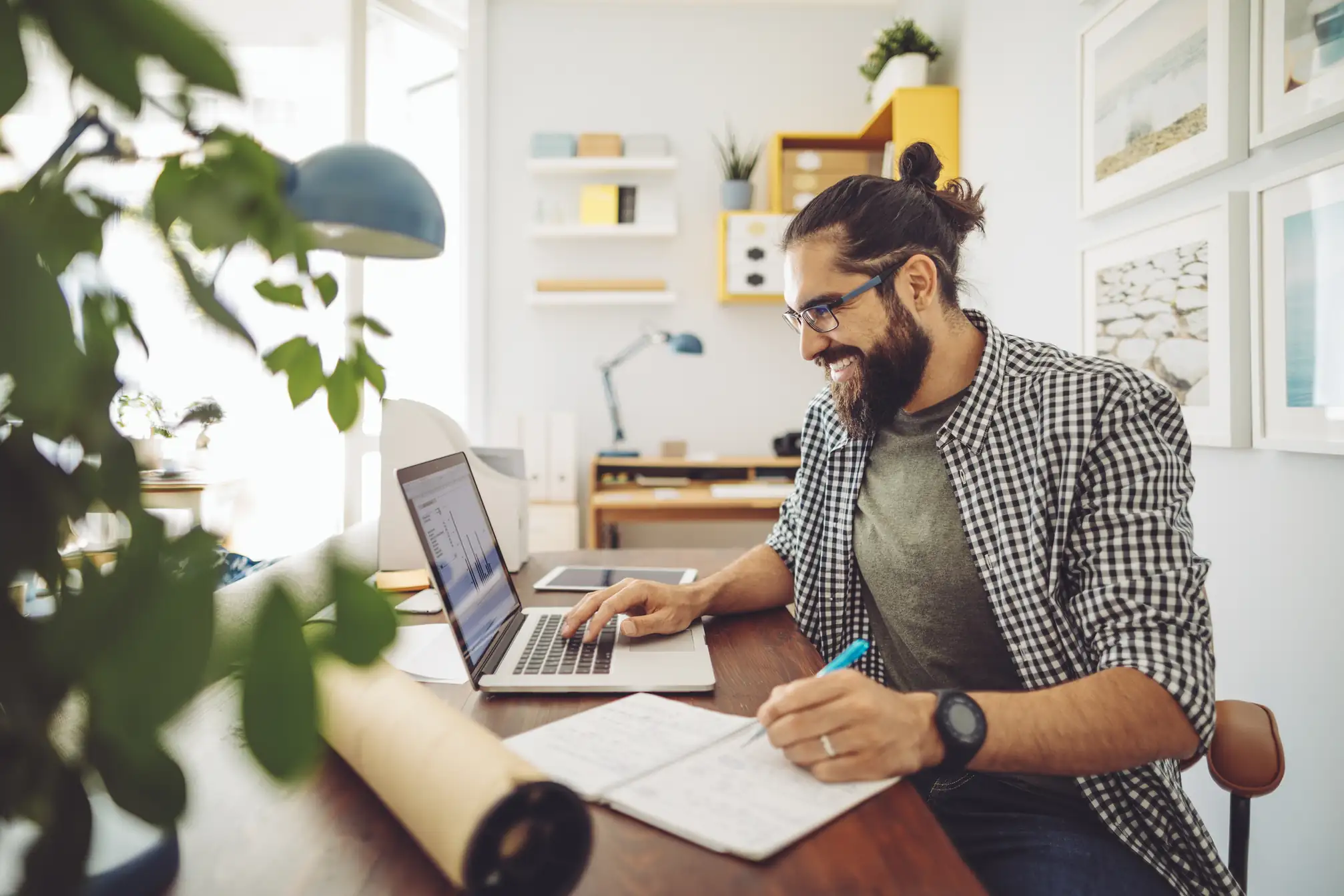 Profissional focado trabalhando em home office com laptop e anotações para aumentar a produtividade