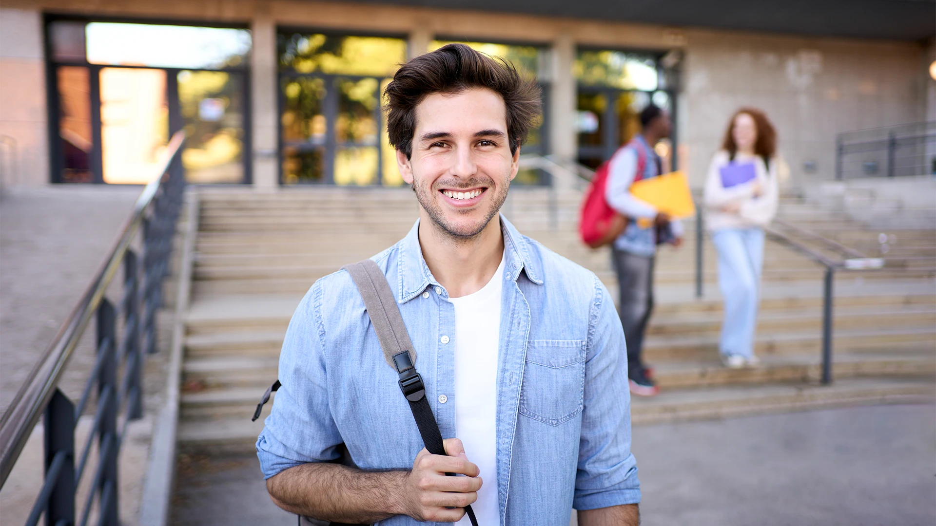 Estudante universitário sorridente com mochila em frente ao campus da faculdade