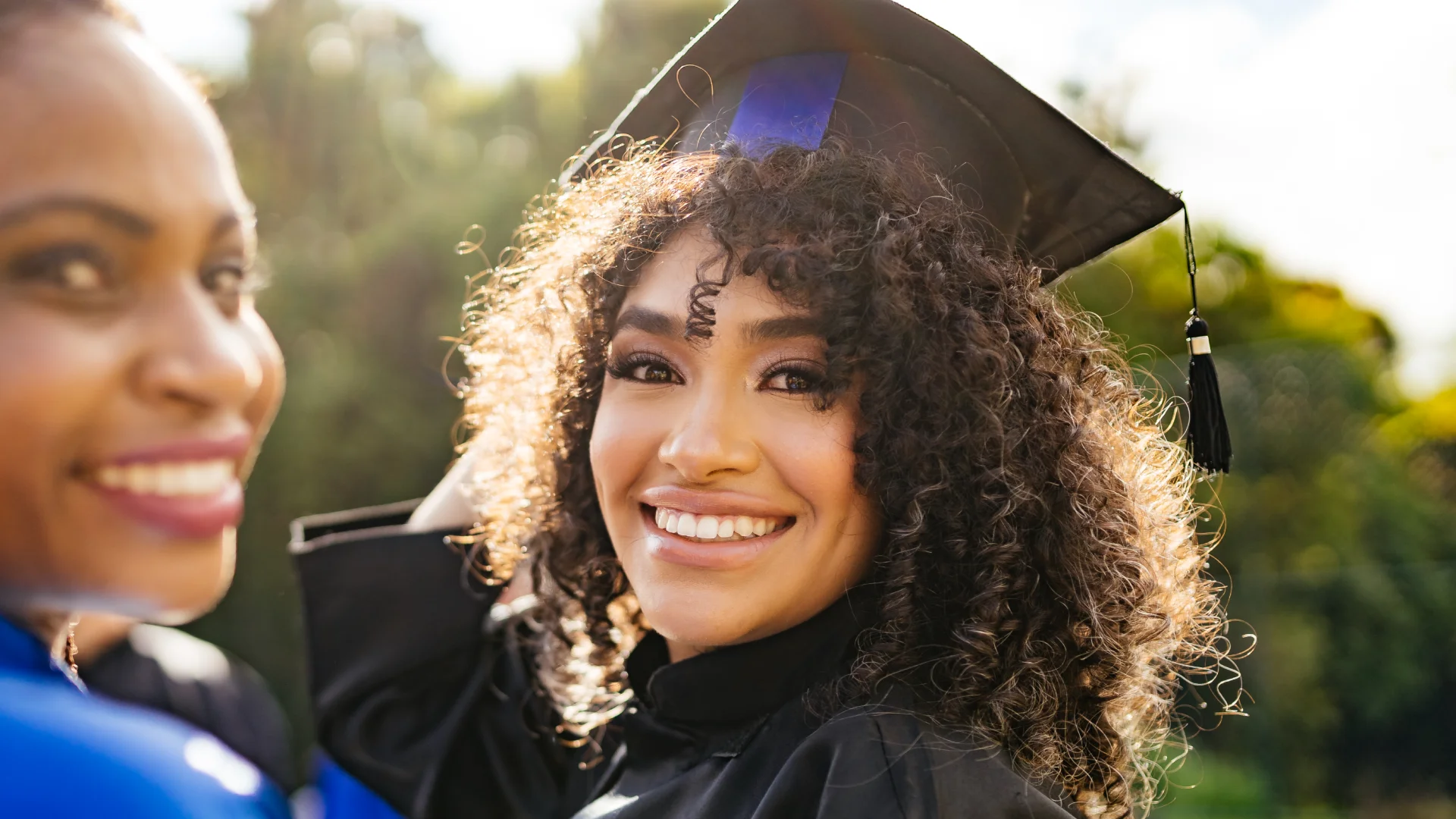 Estudante feliz celebrando sua formatura acadêmica com orgulho e alegria em uma cerimônia universitária ao ar livre