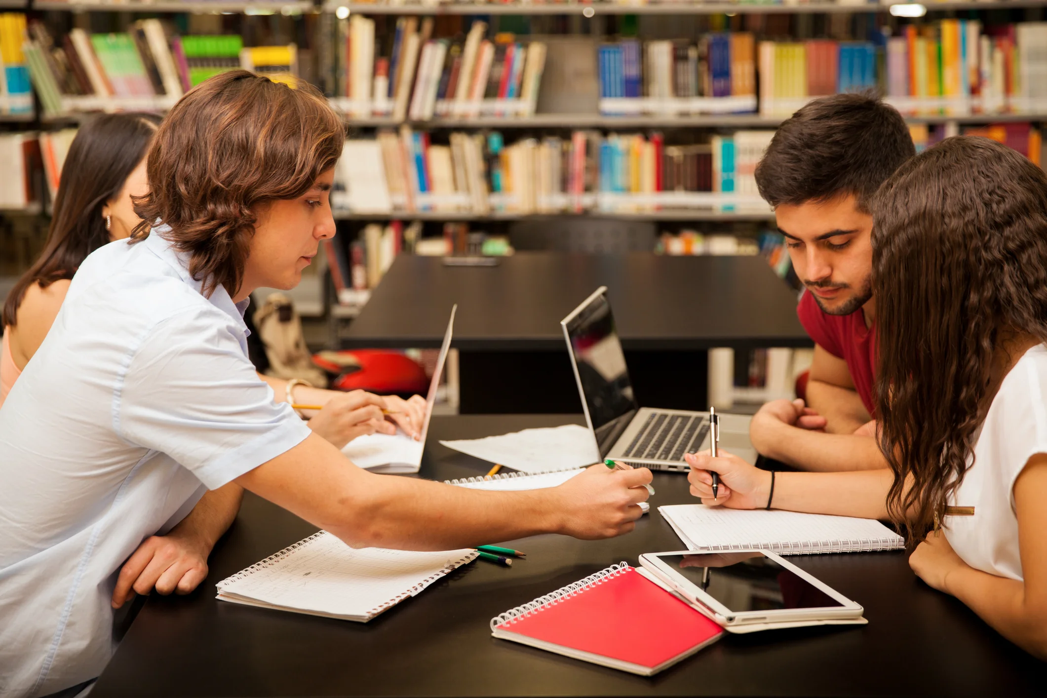 Grupo de estudantes universitários estudando juntos em uma biblioteca