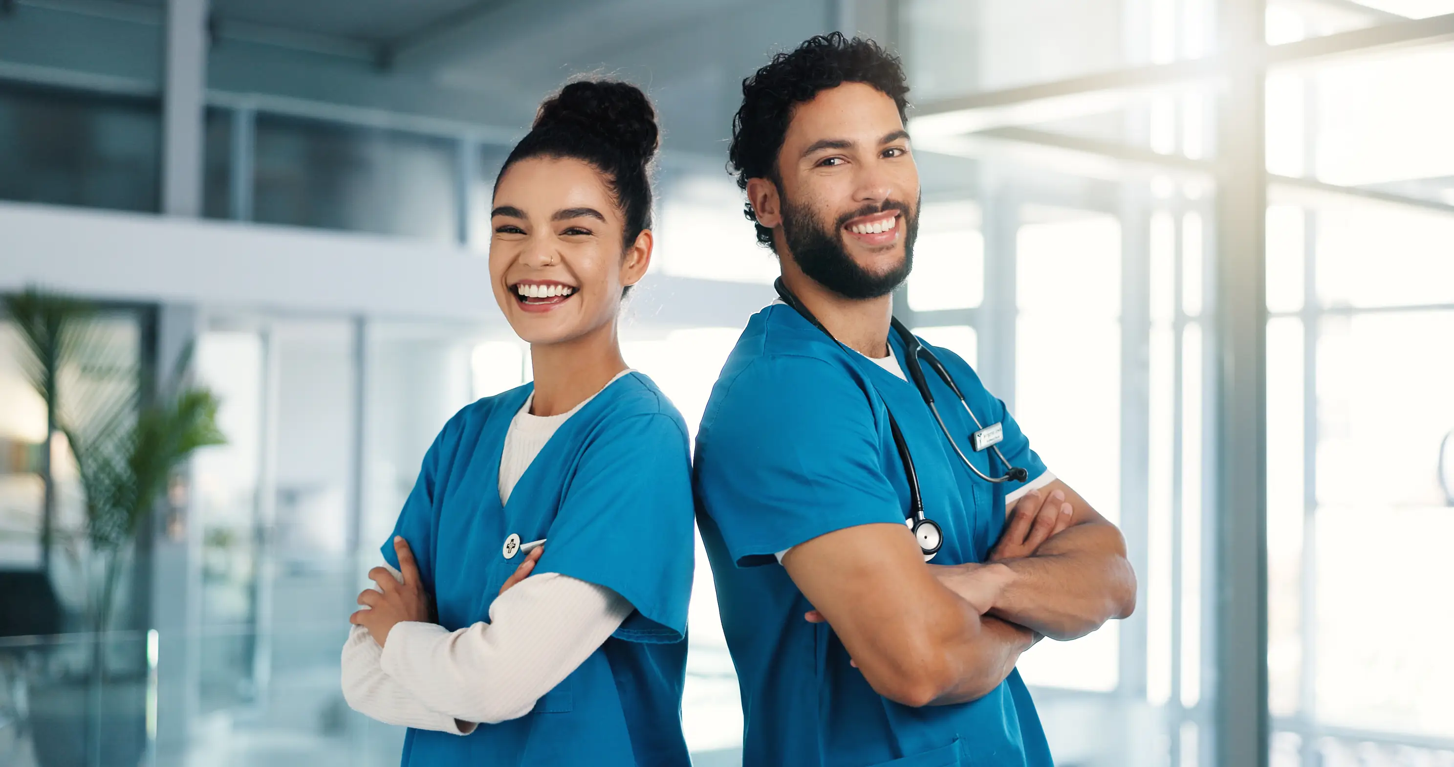 alunos de enfermagem com roupa azul de costas um para o outro