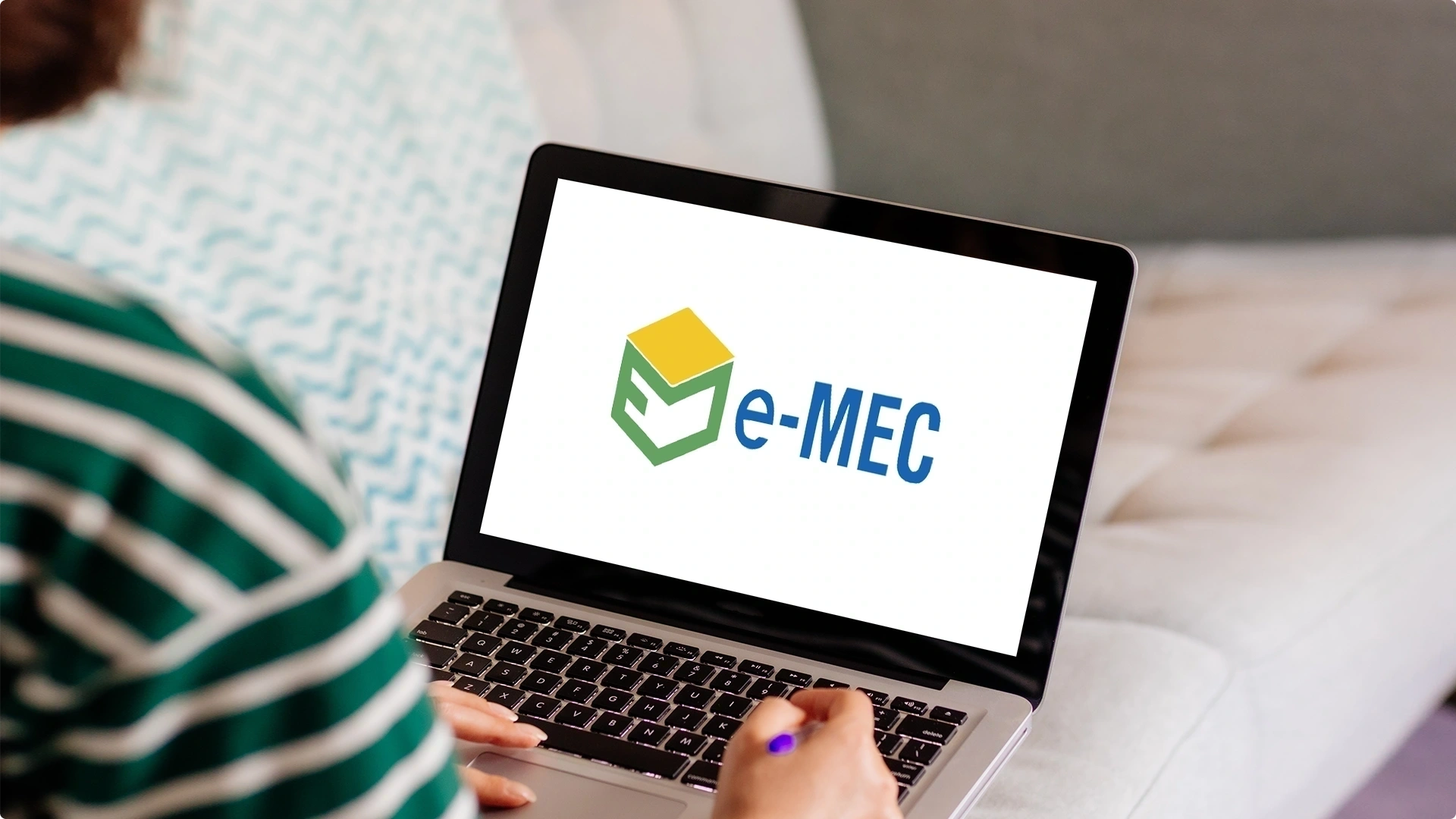 Pessoa utilizando um laptop com o logotipo do sistema e-MEC na tela