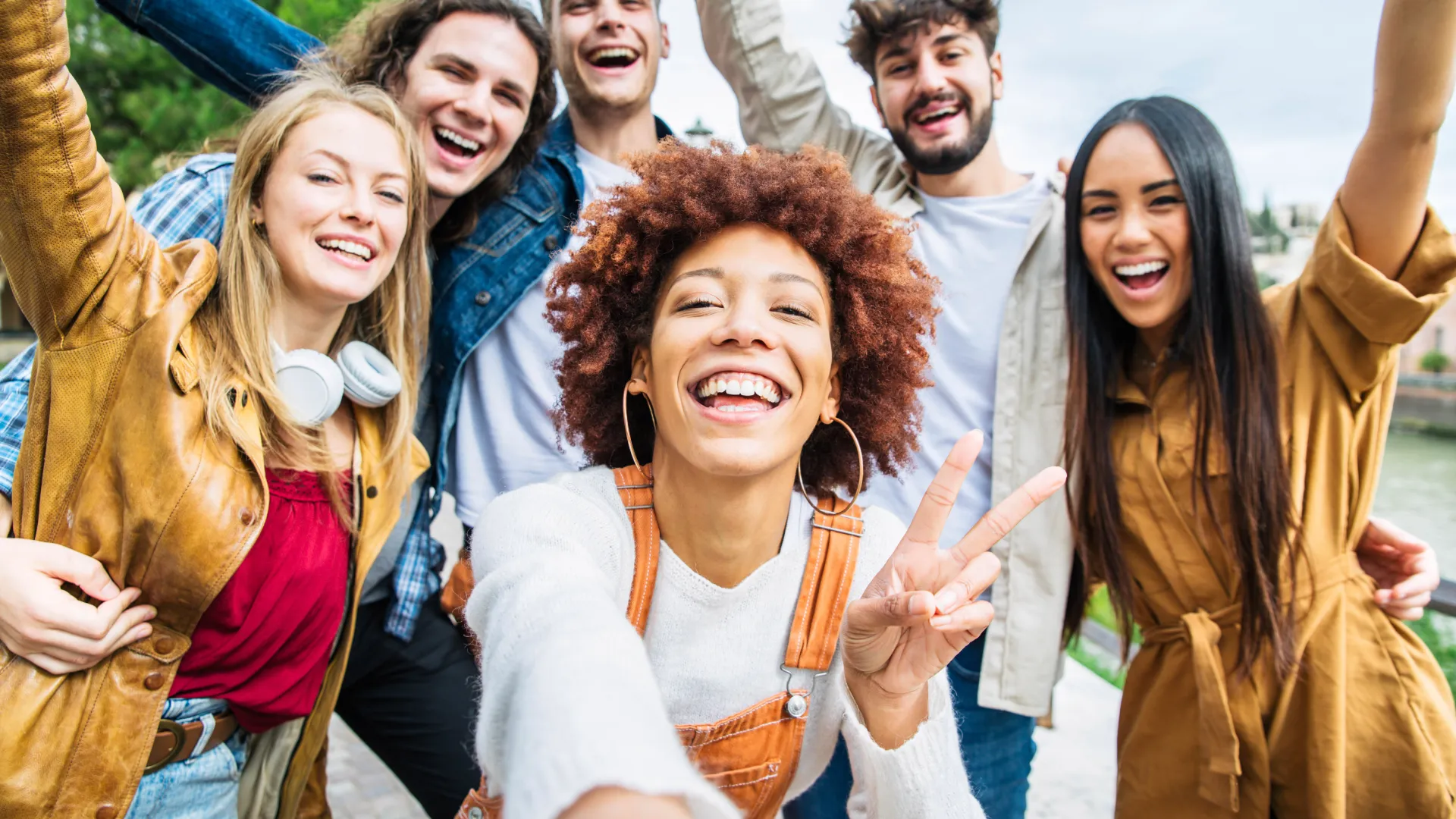 Grupo de amigos estudantes celebrando a vida universitária com uma selfie alegre em um dia ensolarado